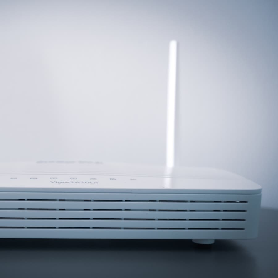 A white wireless router with two upright antennas on a plain surface.